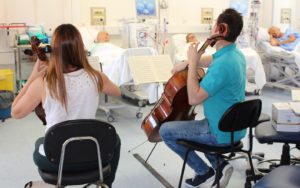 Dos músico tocando para pacientes con diálisis